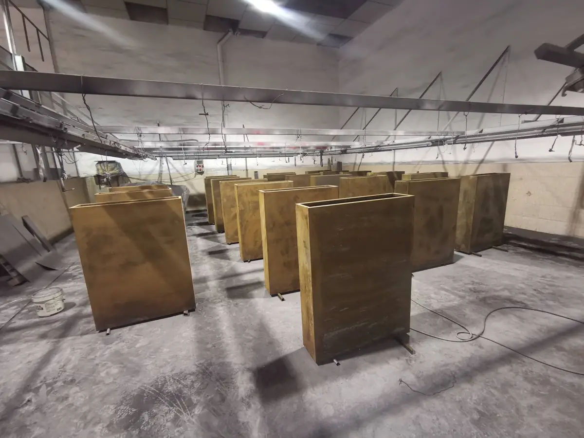 Piezas colgadas en la cabina de lacado en polvo de Pilonatic