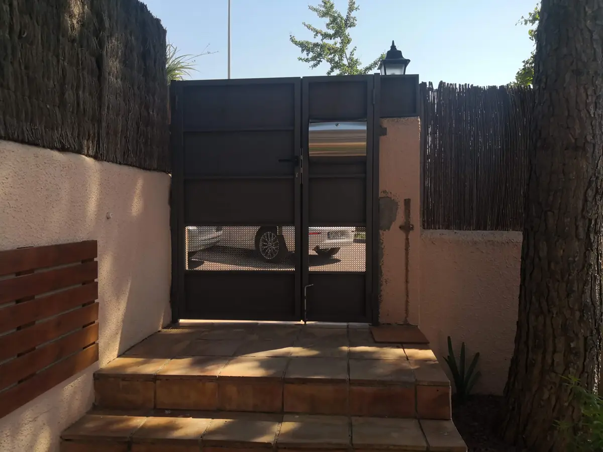Puerta batiente metálica de Pilonatic instalada en una vivienda